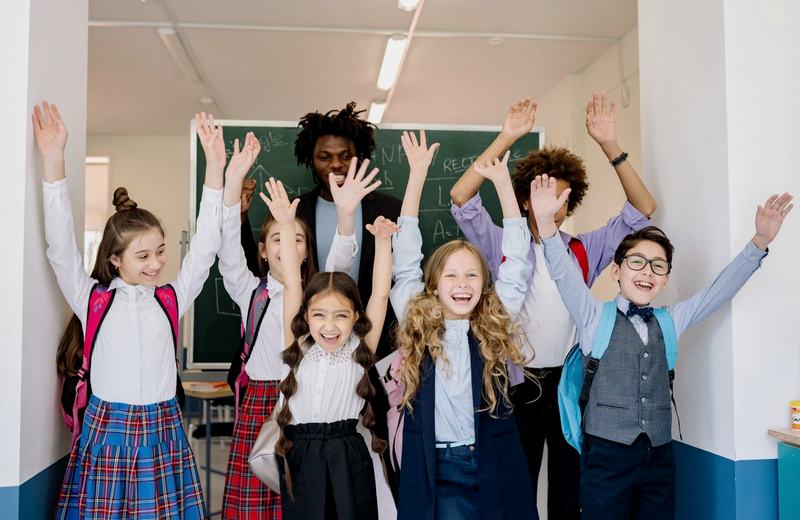 Crianças em sala de aula levantando a mão
