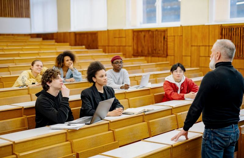 Estudantes universitários em auditório com professor